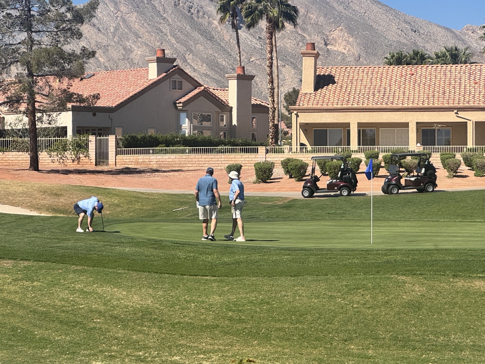 Golfers on a green at Sun City Summerlin, with the Spring Mountains behind the course